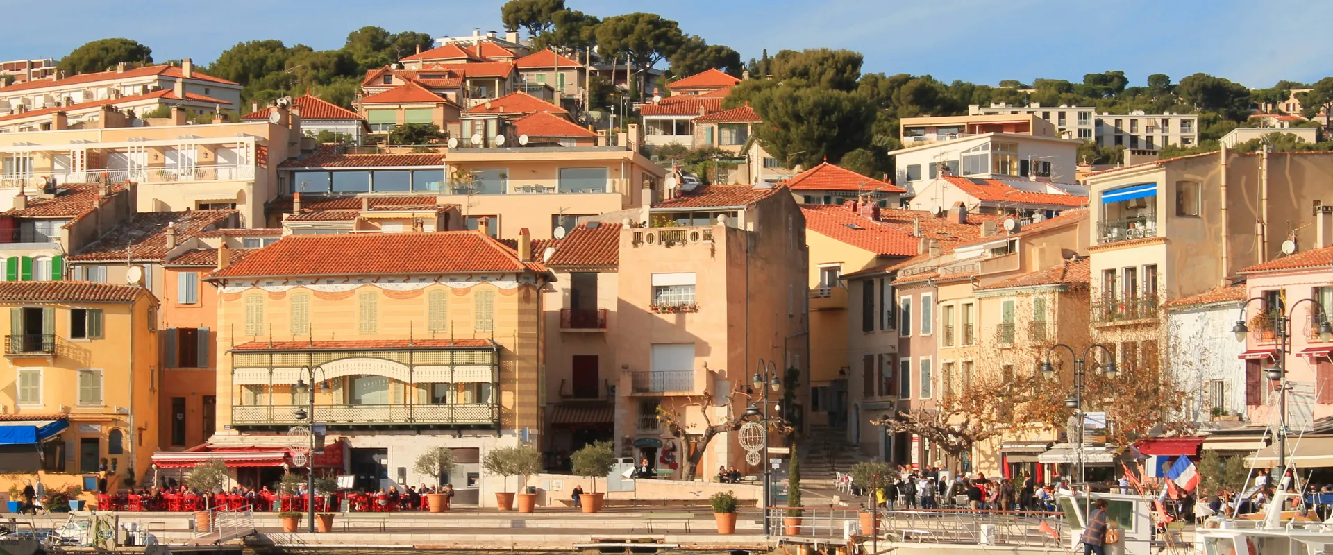 Village côtier méditerranéen avec maisons colorées et toits oranges au bord de l'eau