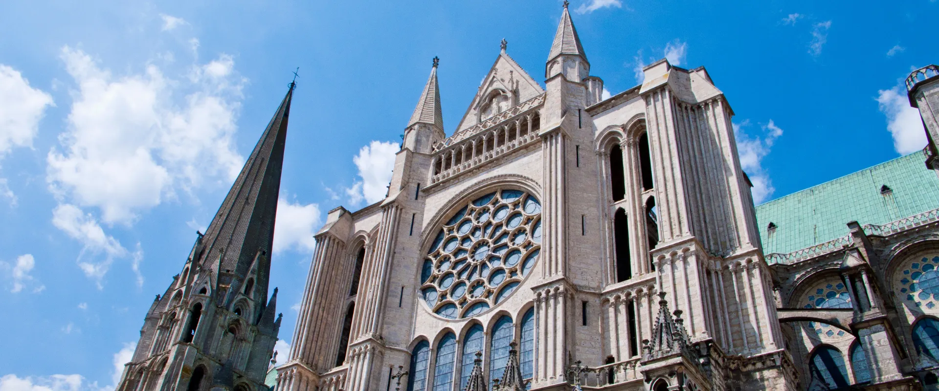 Cathédrale gothique de Chartres avec ses tours et rosace sous ciel bleu.