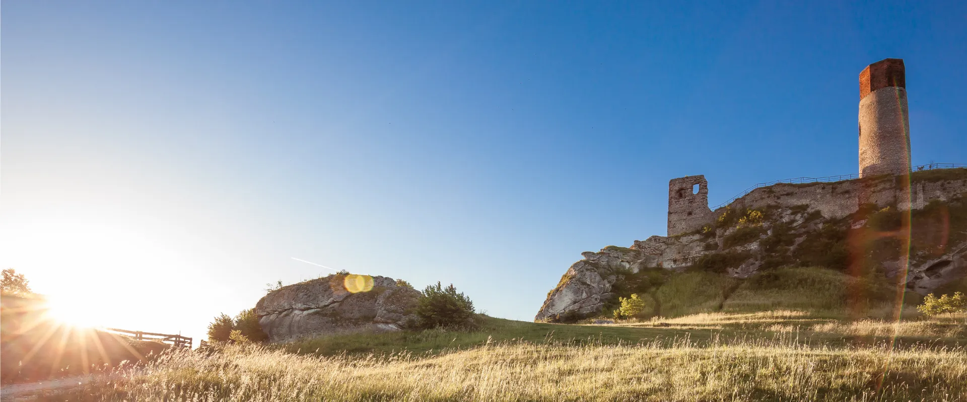 Ruines de forteresse médiévale avec tour en pierre au coucher du soleil dans le Jura.