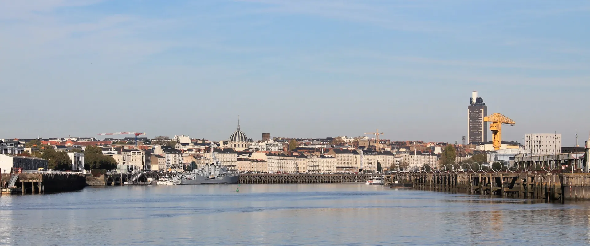 Vue panoramique de Nantes avec la Loire, bâtiments historiques et dôme caractéristique.