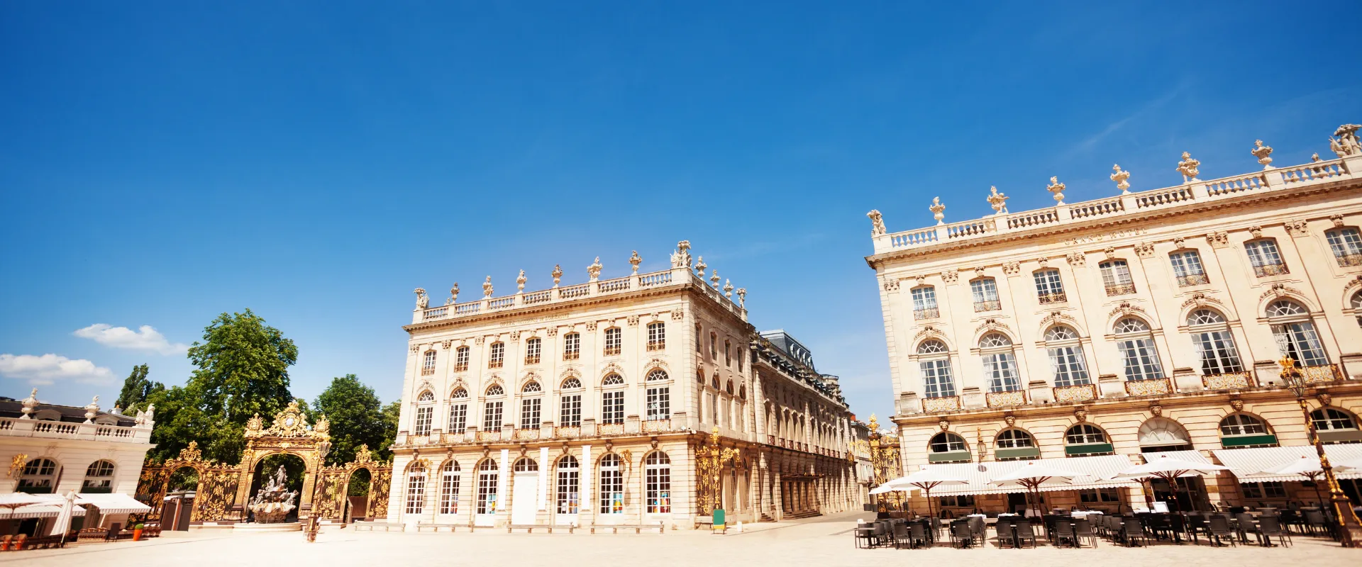 Place de la Carrière à Nancy avec ses bâtiments classiques dorés et ciel bleu.