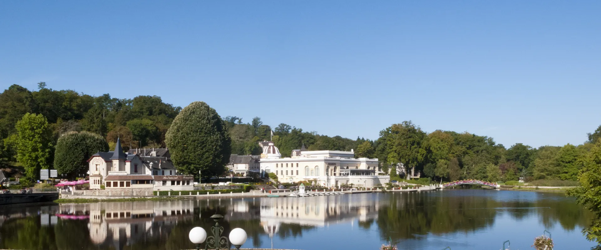 Château de Brécy au bord de l'eau avec jardins et arbres, Orne.