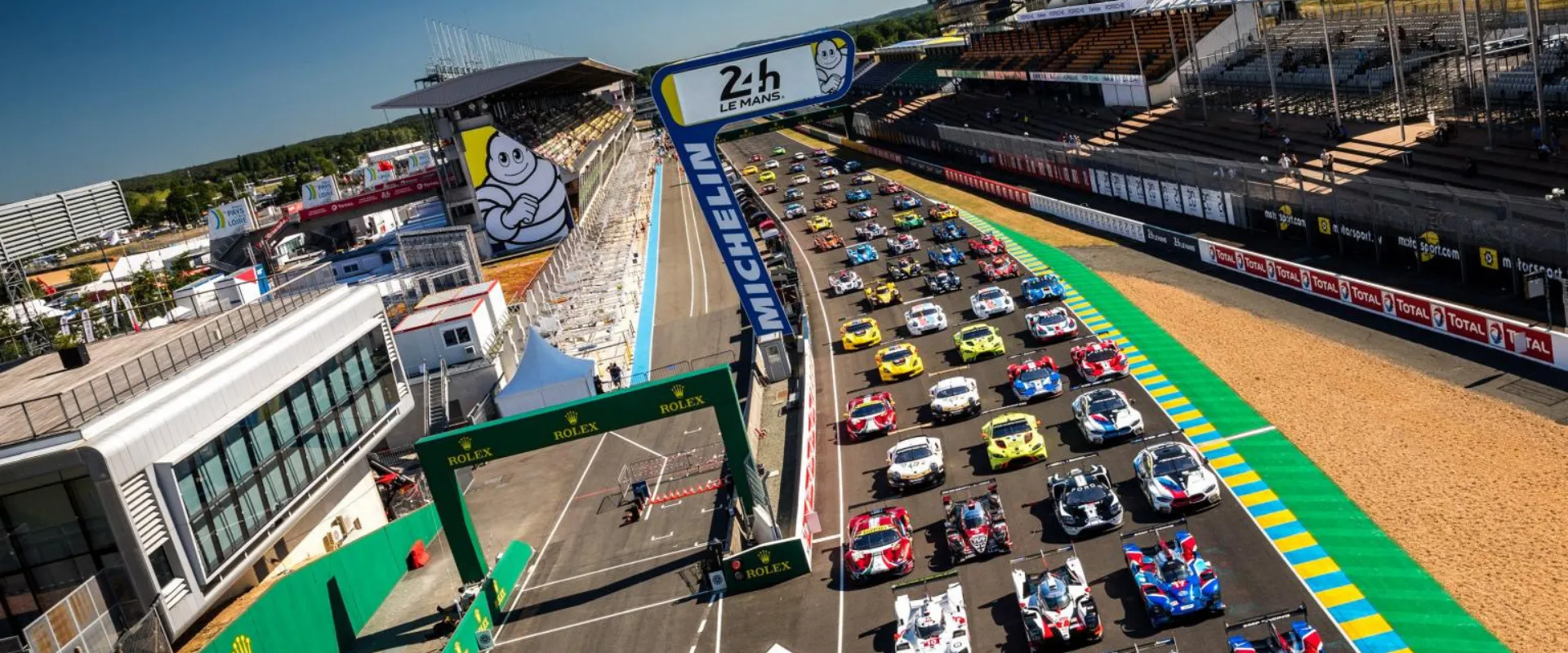 Grille de départ 24 Heures du Mans avec voitures de course alignées sur circuit.