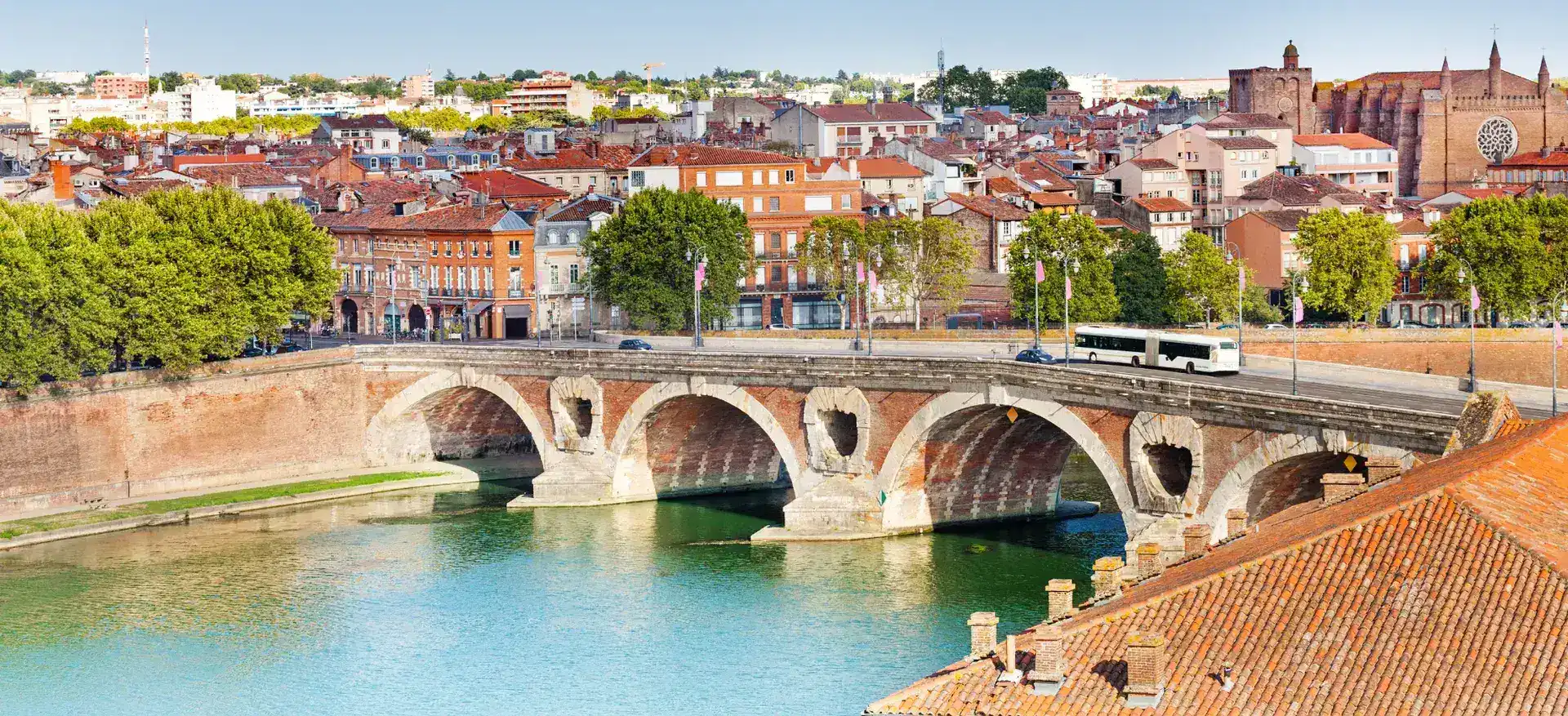 Toits en tuile canal toulousaine avec panneaux solaires, vue sur la ville rose
